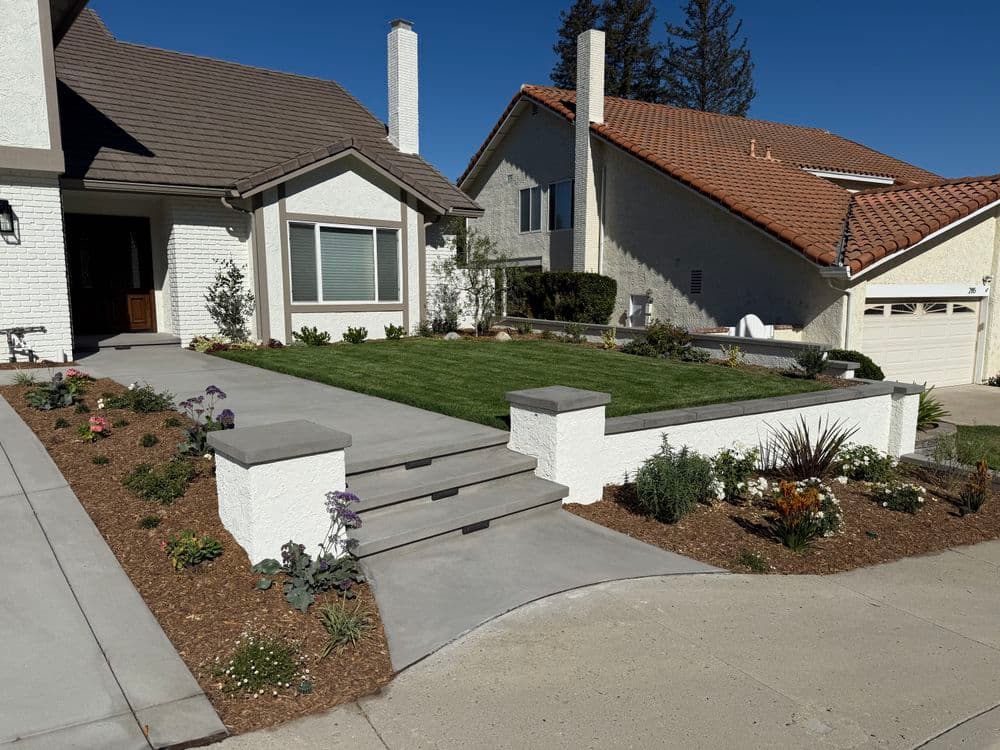 Wooden sliding gate with metal frame in residential outdoor setting under blue sky.